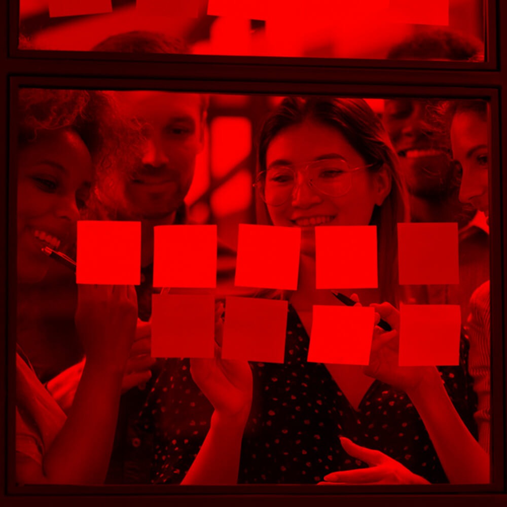 a group of people holding sticky notes